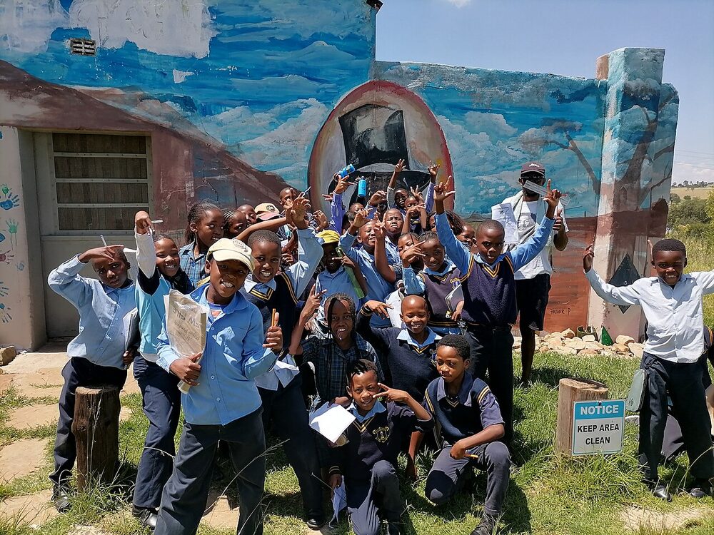 South African primary school pupils in uniform, celebrating together outside their school
